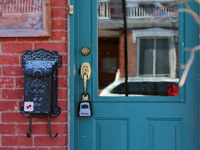 Montreal, QC / Canada - March 25 2019: the key lock box is installed outside Plateau Mont Royal apartment, one of many. Airbnb infestation of trendy neighborhoods leads to evictions and less rentals, ManagedBNB
