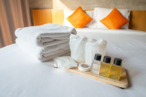 Set of hotel amenities (such as towels, shampoo, soap, drinking glass etc) on the bed. Hotel amenities is something of a premium nature provided in addition to the room when renting a room, ManagedBNB